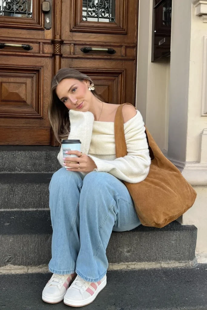 Cream Off-Shoulder Sweater with Light-Wash Jeans and Sneakers